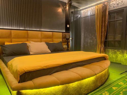 een slaapkamer met een groot bed met een grote gele sprei bij Messiah’s Ark in Srinagar