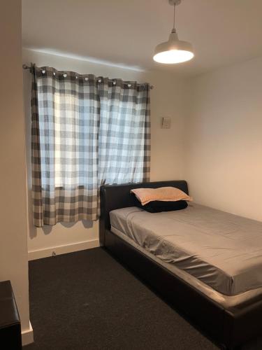 a bedroom with a bed in front of a window at Double Bedroom with Ensuite in Ilford