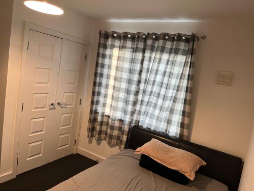 a bedroom with a bed and a window with a curtain at Double Bedroom with Ensuite in Ilford