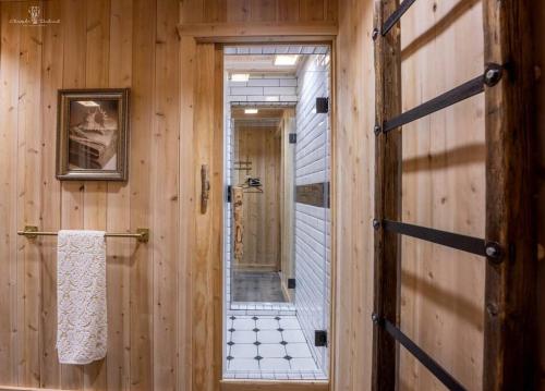 a bathroom with a hallway with a mirror and a door at Chalet Mikua, 6 p. spa, billard, Forêt & Nature in La Malbaie