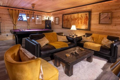 a living room with a couch and a pool table at Chalet Mikua, 6 p. spa, billard, Forêt & Nature in La Malbaie