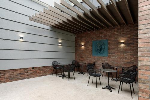 a patio with tables and chairs and a brick wall at Richmond Hotel in Chişinău