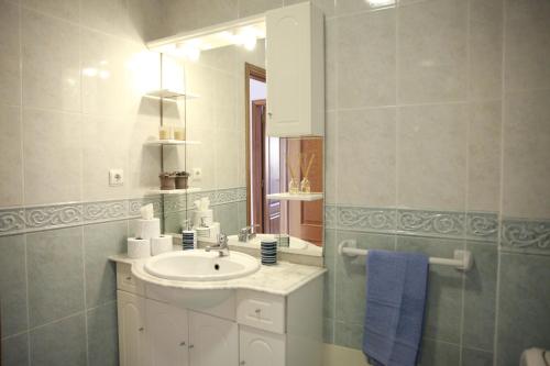 y baño con lavabo y espejo. en Casa Do Shon, en Óbidos