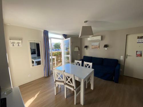 un salon avec une table et un canapé bleu dans l'établissement Les Dunes du Soleil, à La Grande Motte