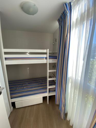 une chambre avec un lit superposé et une fenêtre dans l'établissement Les Dunes du Soleil, à La Grande Motte