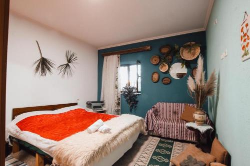 um quarto com uma cama com um cobertor vermelho em BB Apartament em Gjirokastër