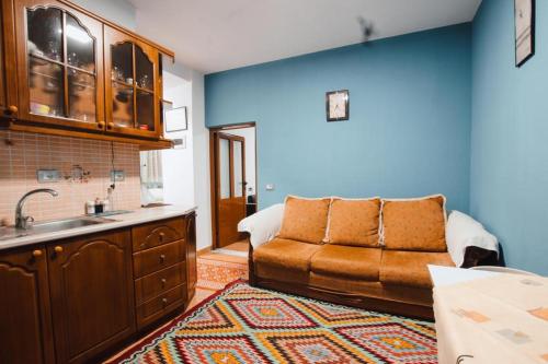uma cozinha com um sofá e um lavatório em BB Apartament em Gjirokastër