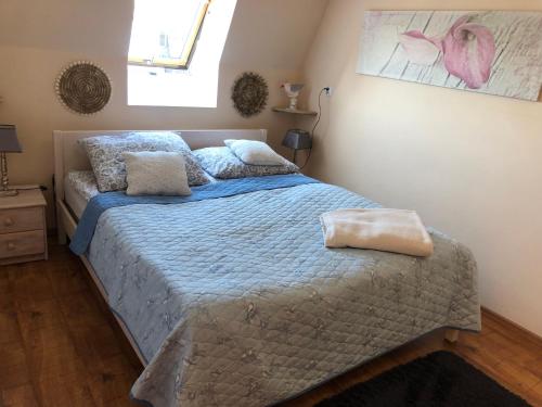 sypialnia z łóżkiem z niebieską kołdrą i oknem w obiekcie Apartament Na Wydmie w Ustce