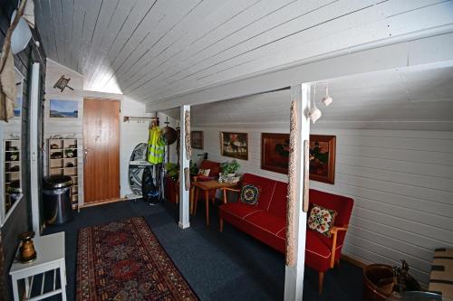 a living room with a red couch and a table at Rivdnji Holiday Home Smørfjord in Russenes