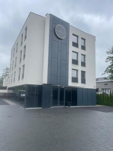 Un edificio con un orologio sul lato. di Hotel Parrot a Raszyn