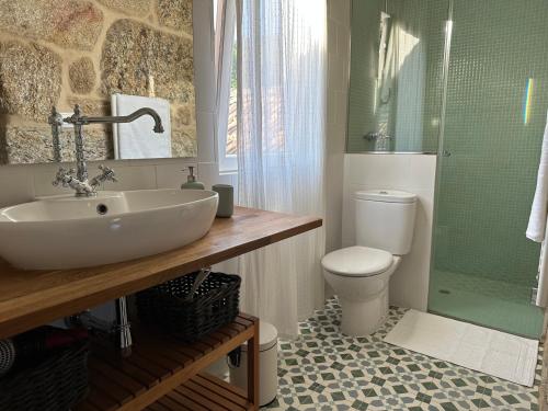 uma casa de banho com um lavatório, um WC e um chuveiro em Casa La Antigua Escuela em Mondariz