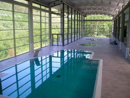 a large swimming pool in a building with windows at As Fontaiñas 
