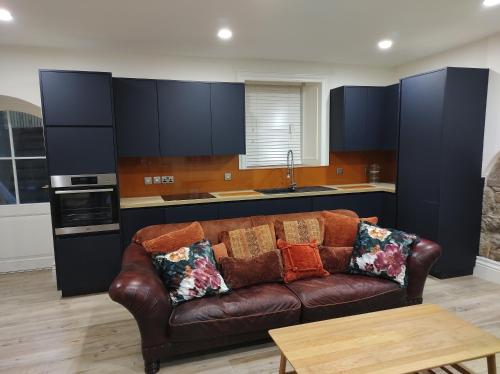 ein Wohnzimmer mit einer braunen Couch in einer Küche in der Unterkunft Prizon House Balla in Mayo