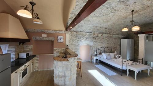 una cucina e un soggiorno con divano in camera di Stone House Apartments Didini Dvori Lumbarda a Lumbarda (Lombarda)