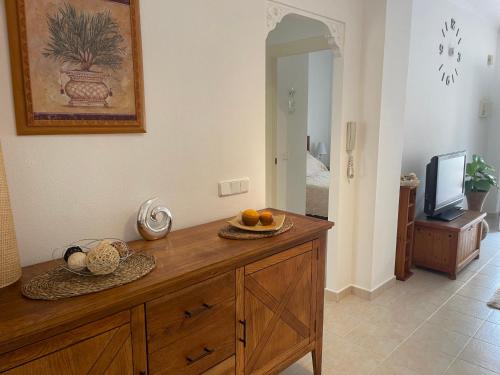 Cette chambre comprend une commode en bois avec des oranges. dans l'établissement Holiday Home Amari - Residencia Albatros, à Los Alcázares