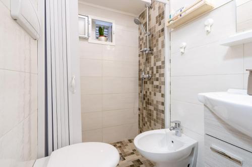 uma casa de banho branca com um WC e um lavatório em Chiarina rooms 2 em Polignano a Mare