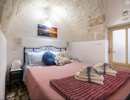 um quarto com uma cama grande e toalhas em Chiarina rooms 2 em Polignano a Mare