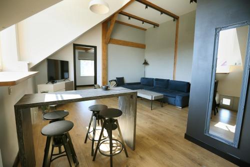 a kitchen and living room with a bar and stools at Nora Sky in Nida