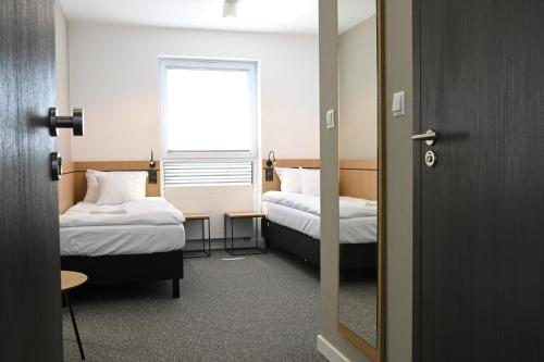 mały pokój z 2 łóżkami i oknem w obiekcie Hotel Parrot w Raszynie