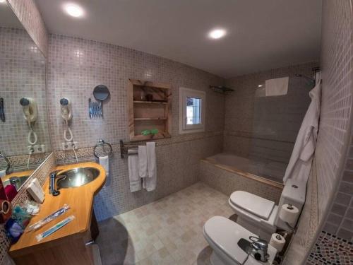 uma casa de banho com um lavatório, um WC e uma banheira em Luxury White Castle Ibiza em Sant Rafael de Sa Creu