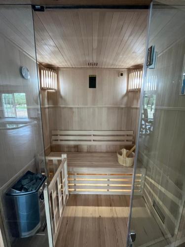 una sauna con pavimento in legno e parete in vetro di La Tour Bornéo du Château Saint-Laurent a Saint-Laurent-de-Médoc