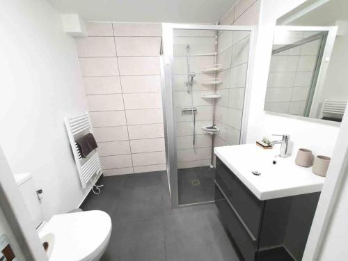 een badkamer met een douche, een wastafel en een toilet bij L'Eiffel - Self Checking, 20min from Paris in Drancy