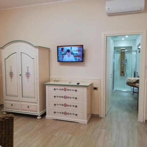 a room with a dresser and a tv on the wall at Incanto d'Etna in Giarre