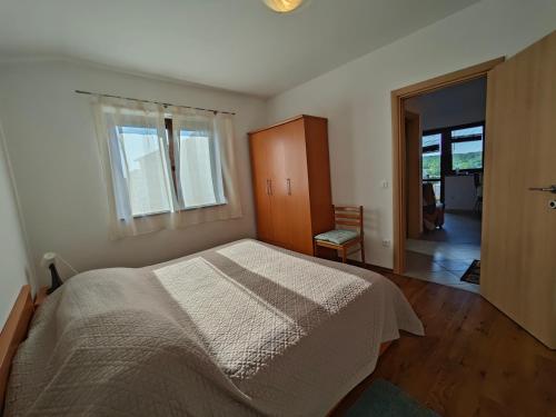 a bedroom with a large bed and a window at Apartments Bevanda in Bale