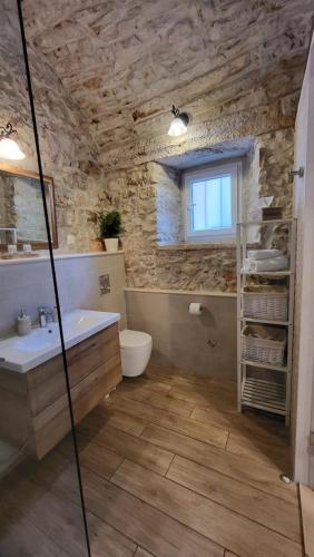 e bagno con vasca, servizi igienici e lavandino. di Stone House Apartments Didini Dvori Lumbarda a Lumbarda (Lombarda)