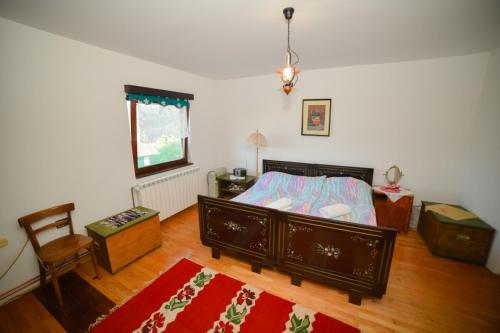 a bedroom with a bed and a table and a chair at Medjedovica Brdo Godovik in Godovik