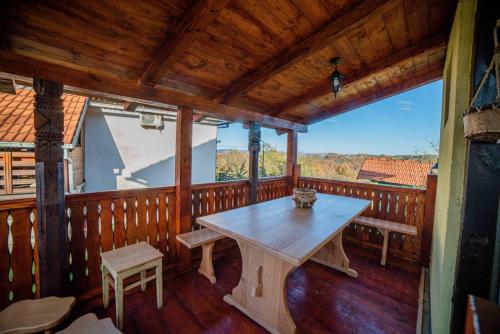 a wooden screened in porch with a table and benches at Medjedovica Brdo Godovik in Godovik