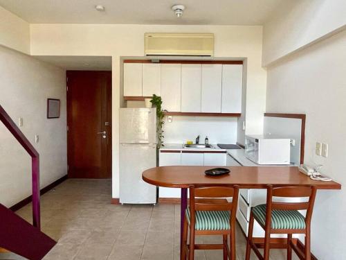 a kitchen with a table and chairs and a refrigerator at Cómodo duplex en centro de Miraflores in Lima