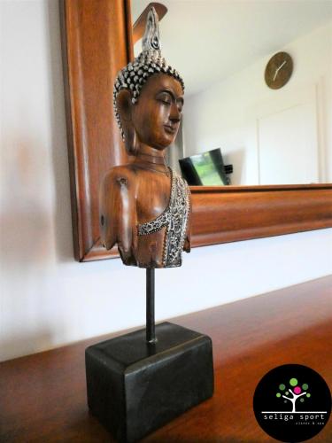 a statue of a buddha statue on a table at Seliga Sport Apartments & SPA in Lesznowola