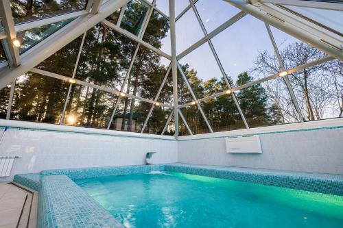 Suniši的住宿－Lakeside Escape，一座带大型玻璃天花板的室内游泳池