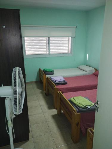 Cette chambre comprend 4 lits et une fenêtre. dans l'établissement JMC, à Jesús María