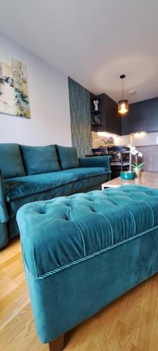 a living room with a blue couch in a room at Apartman 49 in Subotica