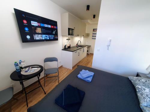 Zimmer mit einem Bett und einem Tisch sowie einer Küche in der Unterkunft Apartamenty u Portera w Śródmieściu in Gdynia