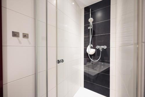 a bathroom with a shower with black and white tiles at Hotel Busche am Dom in Münster