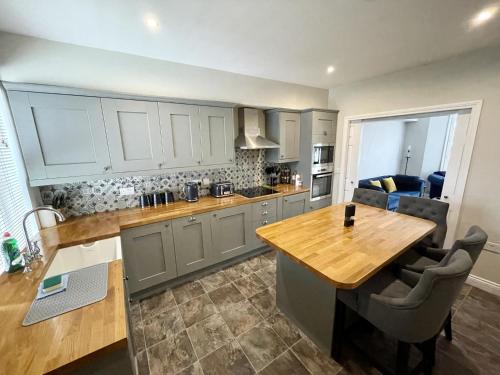 a kitchen with a wooden counter top and a table at Modern Maisonette in Vibrant Bristol, Free Parking in Bristol