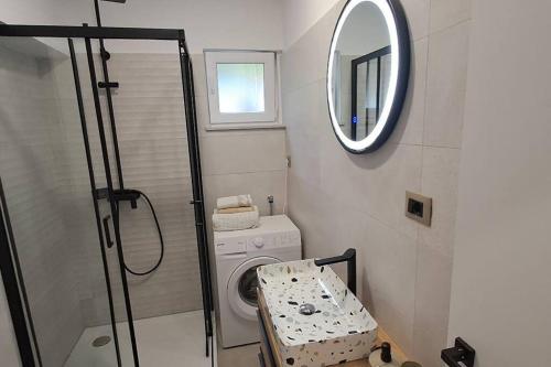 een badkamer met een wasmachine en een spiegel bij Maris in Omiš
