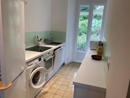 eine Küche mit einer Waschmaschine und einem Waschbecken in der Unterkunft Joli appartement dans le centre ville de Corte in Corte