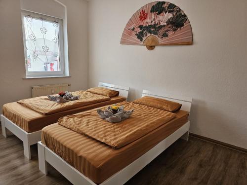 Dos camas en un dormitorio con dos cuencos. en Käthe-Kollwitz-Straße 54, F2, en Altemburgo