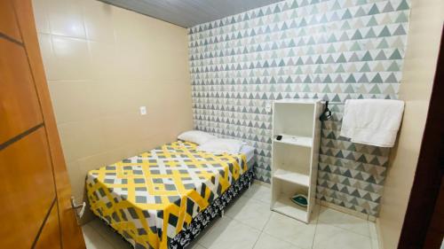 a small bedroom with a yellow and black bed at Apartamento 3 Aconchegante São Jorge in Manaus