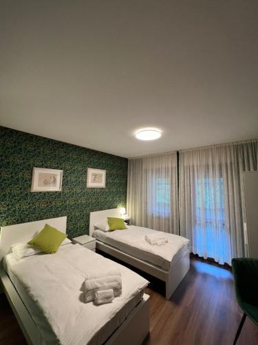 a hotel room with two beds and a window at Belvedere da Cesarina in Tarvisio