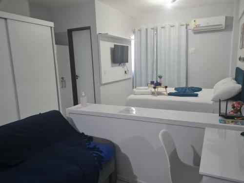 ein weißes Badezimmer mit einem großen Spiegel und einem Waschbecken in der Unterkunft Manaíra Flat 206 Em frente ao shopping Manaíra in João Pessoa