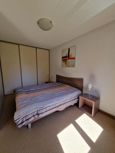 a bedroom with a bed and a lamp on a table at Home sweet Valberg in Péone