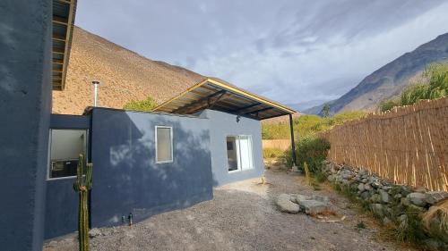 a blue house with a fence next to it at Reset Elqui in Alcoguaz