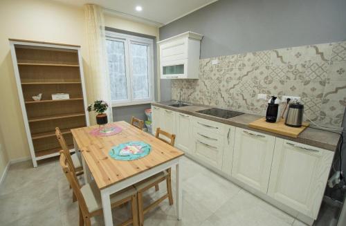 uma cozinha com uma mesa de madeira, uma mesa e cadeiras em Via Cino Cagliari em Cagliari