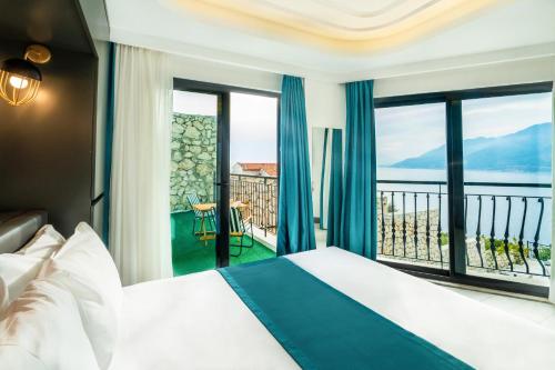 a hotel room with a bed and a view of the ocean at Gümüş Yazar Hotel in Kaş