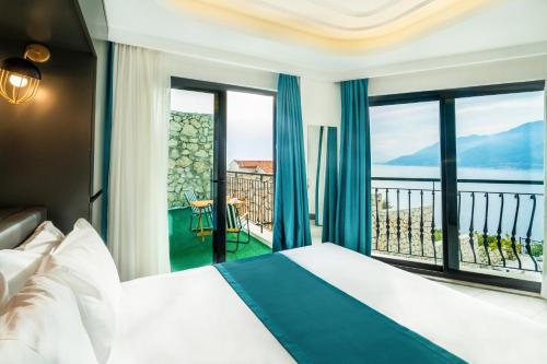 Gumus Peninsula Hotel في كاس: غرفة فندقية بسرير وإطلالة على المحيط